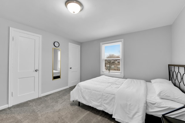 bedroom featuring light colored carpet and baseboards