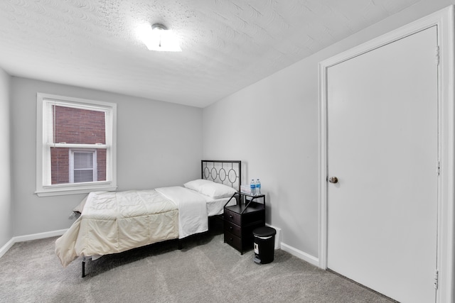 carpeted bedroom with baseboards and a textured ceiling