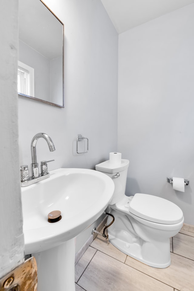 bathroom featuring a sink, toilet, and wood finished floors