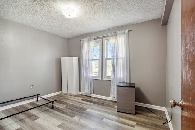 empty room featuring light hardwood / wood-style floors and a textured ceiling