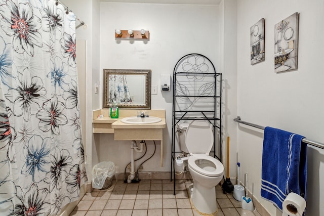 bathroom featuring toilet, tile patterned flooring, and sink