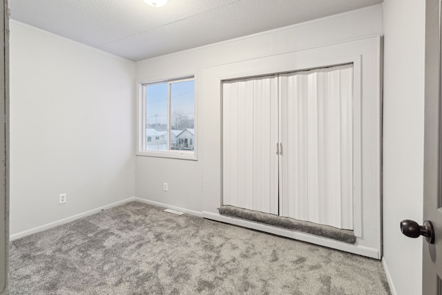 unfurnished bedroom with light carpet and a textured ceiling