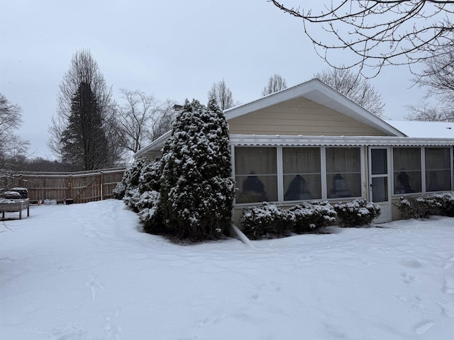 snow covered property featuring a sunroom