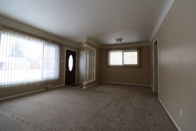 entrance foyer featuring a wealth of natural light and carpet