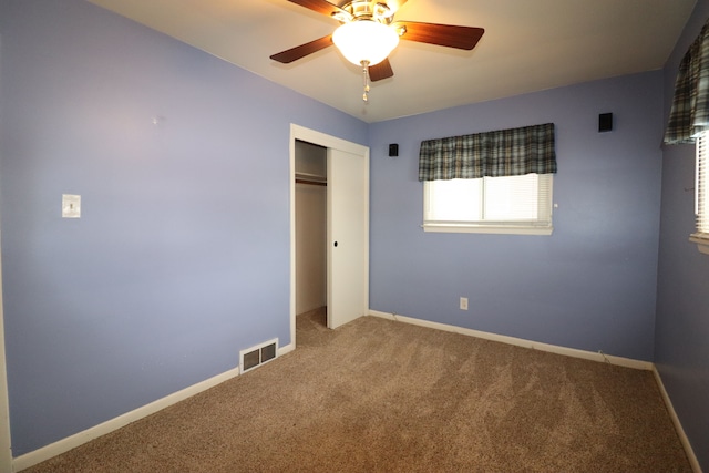 unfurnished bedroom featuring ceiling fan, a closet, and carpet