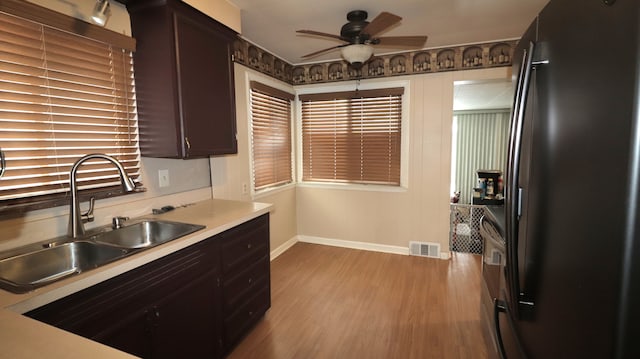 kitchen with sink, ceiling fan, refrigerator, dark brown cabinets, and light wood-type flooring