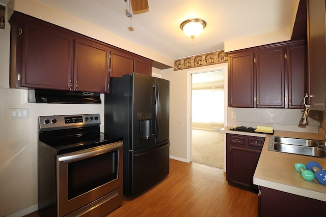 kitchen featuring sink, light hardwood / wood-style flooring, black fridge with ice dispenser, and stainless steel range with electric stovetop