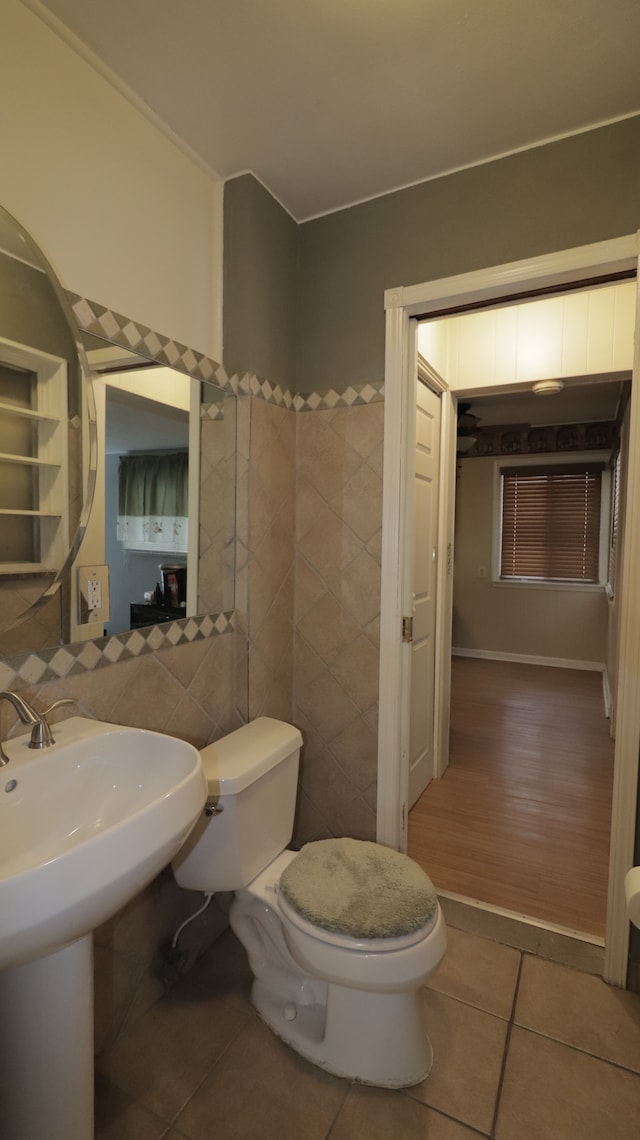 bathroom with tile patterned flooring, tile walls, and toilet