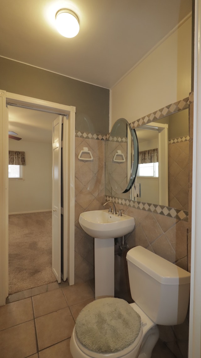 bathroom with tile patterned flooring, sink, tile walls, and toilet