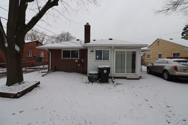 view of snow covered back of property