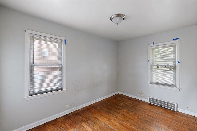 empty room with dark hardwood / wood-style flooring