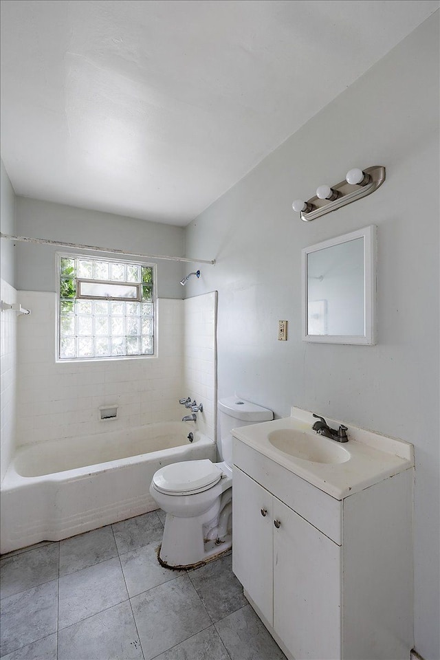 full bathroom featuring vanity, tiled shower / bath, tile patterned floors, and toilet