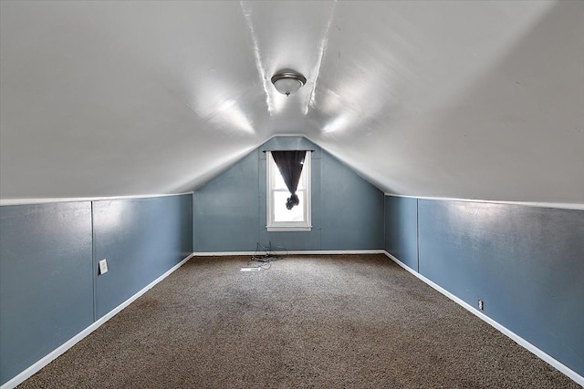 additional living space with vaulted ceiling and carpet floors