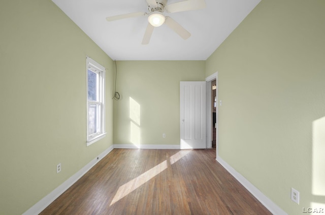 empty room featuring dark wood-type flooring and ceiling fan