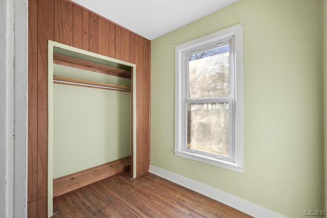 unfurnished bedroom with a closet and dark hardwood / wood-style floors