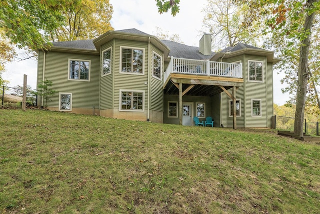 back of house with a wooden deck and a lawn