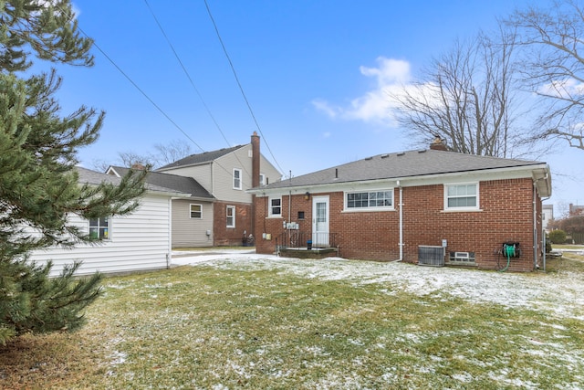 rear view of property featuring cooling unit and a lawn