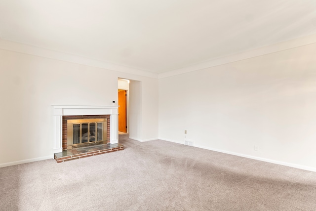 unfurnished living room featuring crown molding, carpet floors, and a brick fireplace