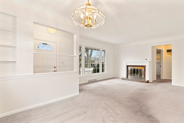 unfurnished living room with a fireplace, built in features, a chandelier, and carpet