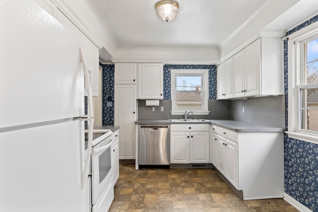 kitchen with plenty of natural light, sink, white cabinets, and white appliances