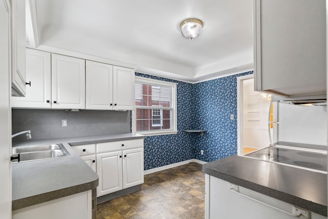 kitchen with sink, cooktop, white cabinets, and white refrigerator