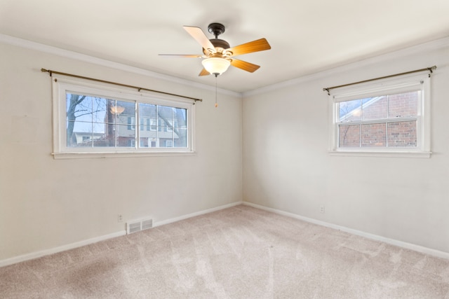 carpeted spare room with crown molding and ceiling fan