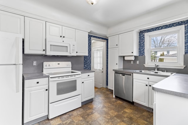 kitchen featuring white appliances, sink, and white cabinets