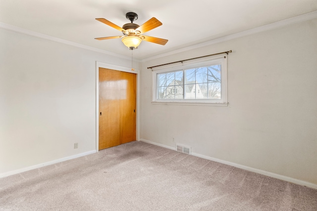 spare room featuring crown molding, carpet flooring, and ceiling fan