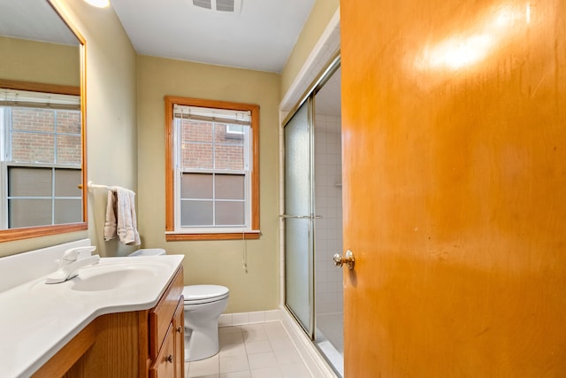 bathroom with vanity, toilet, tile patterned flooring, and a shower with door