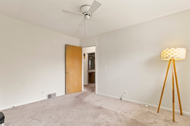 carpeted spare room featuring ceiling fan