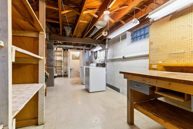 basement with washing machine and clothes dryer and a workshop area