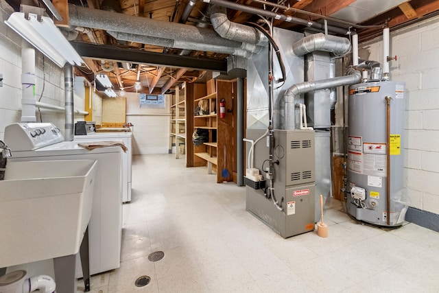 basement with heating unit, sink, water heater, and washing machine and dryer