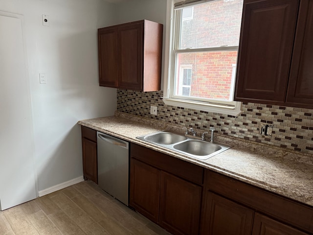 kitchen with sink, backsplash, dark brown cabinets, stainless steel dishwasher, and light wood-type flooring