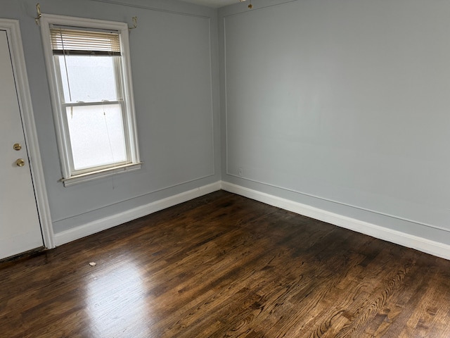 empty room with dark wood-type flooring and plenty of natural light