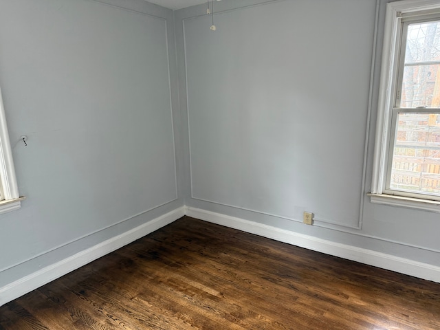 unfurnished room with dark wood-type flooring