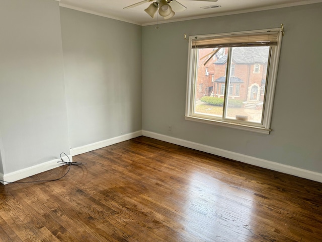 spare room featuring dark wood-type flooring, ornamental molding, and ceiling fan