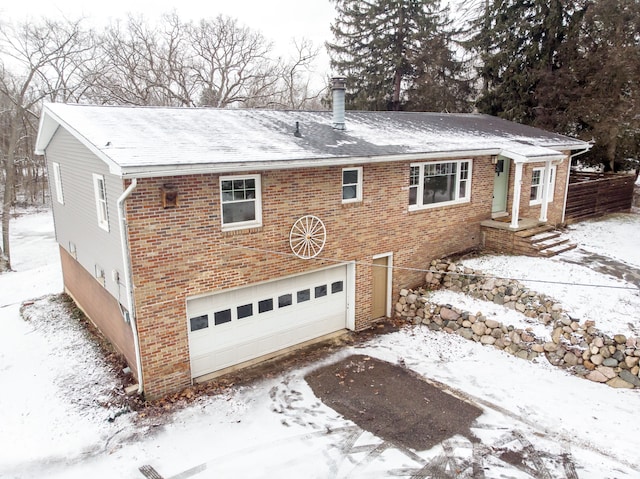 view of front of property featuring a garage, a chimney, and brick siding