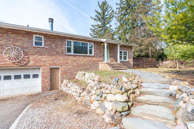 view of front of house with brick siding, an attached garage, and driveway