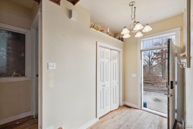 entryway featuring light hardwood / wood-style flooring and a notable chandelier