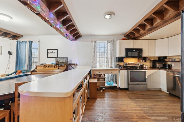 kitchen featuring dark wood-type flooring, stainless steel appliances, and white cabinets