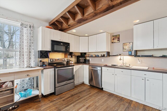 kitchen with white cabinetry, sink, stainless steel appliances, and dark hardwood / wood-style floors