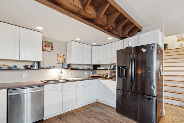 kitchen with white cabinetry, refrigerator with ice dispenser, and stainless steel dishwasher