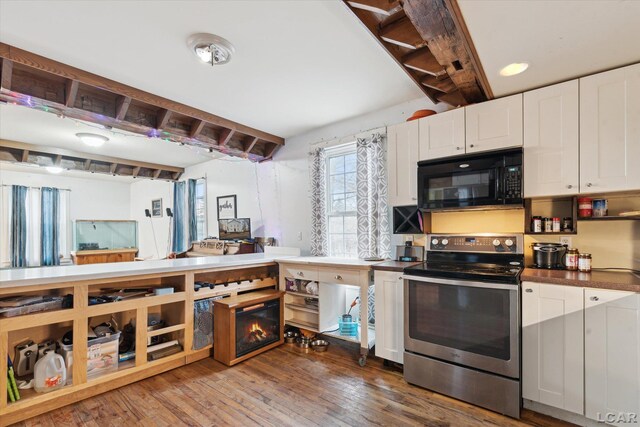 kitchen with white cabinetry, dark hardwood / wood-style floors, and stainless steel range with electric cooktop