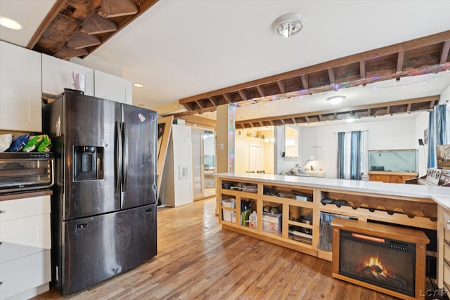 kitchen with white cabinets, stainless steel fridge, and light hardwood / wood-style floors