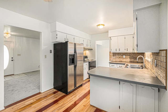 kitchen with white cabinetry, sink, kitchen peninsula, and stainless steel refrigerator with ice dispenser