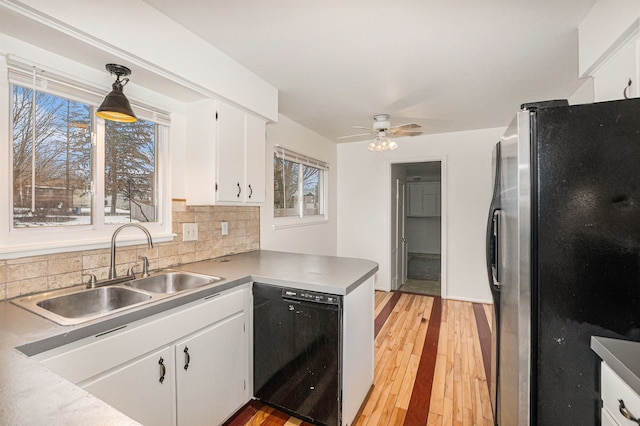 kitchen with pendant lighting, sink, dishwasher, white cabinetry, and stainless steel fridge with ice dispenser