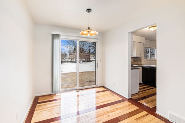 unfurnished dining area with plenty of natural light and light hardwood / wood-style floors