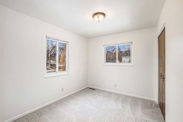 carpeted empty room with a healthy amount of sunlight