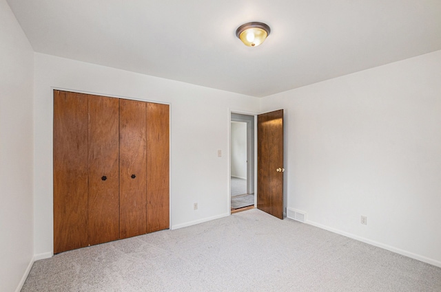 unfurnished bedroom featuring a closet and light carpet