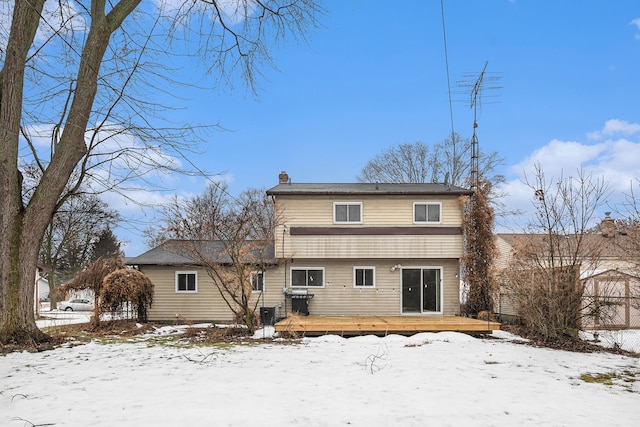 snow covered property with a deck